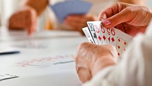 Close-up of players holding cards during a game, demonstrating the dynamics of bluffing and strategy in how to play BS (Bullshit).