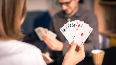 Two players engaging in a game of cards, with one showing their hand, demonstrating the strategies and dynamics of how to play Spades with 2 people.