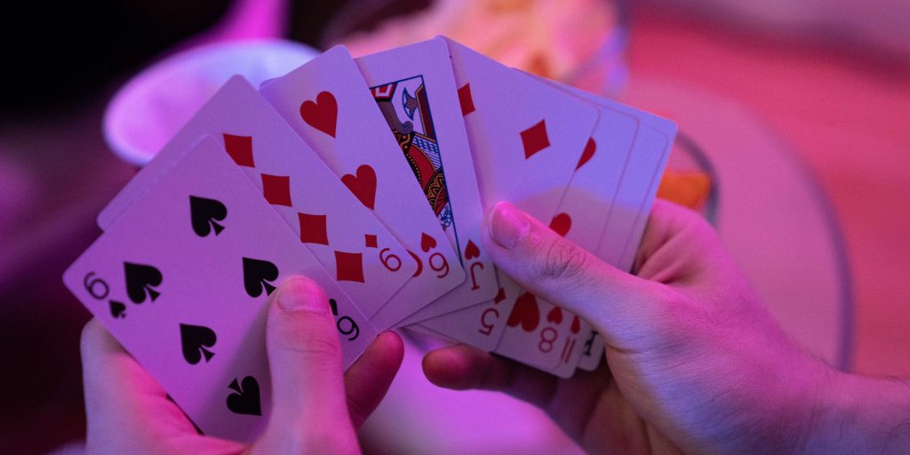 Close-up of a player holding a hand of cards, featuring spades and diamonds, highlighting the strategic play involved in can you play Spades with 3 people.