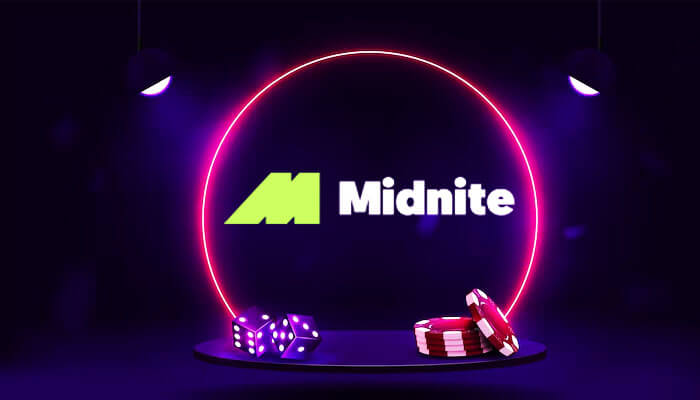 A dark-themed gaming scene featuring a glowing neon pink circular frame with the 'Midnite' logo in the center. Below the logo, there are purple dice and red poker chips displayed on a round platform, illuminated by two overhead spotlights.