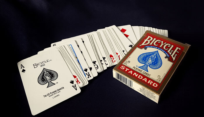 Bicycle playing cards Standard edition spread out on a dark fabric background, featuring the Ace of Spades and full deck.