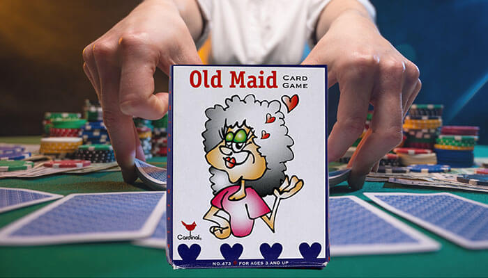 Old maid card game box with a cartoon character placed on a poker table, illustrating how to play old maid game with cards and rules.