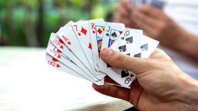 A player holding a fan of playing cards during a lively match, showing a full hand ready for a turn — perfect example for learning Swoop card game rules and strategies.