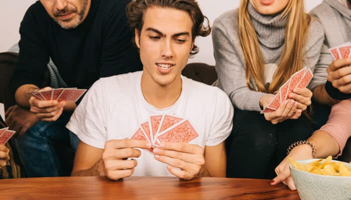 Discard Pile Tactics - Live Casino Magic - Live CasinoMagic A player holding a Queen and 6 of Diamonds, as cards are played in a Canasta game, showcasing strategy for how to play Canasta effectively