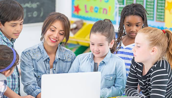 Tech development - Live casino magic - Live CasinoMagic Classroom 15x Games featuring a teacher guiding students through educational games on a laptop to enhance engagement and teamwork