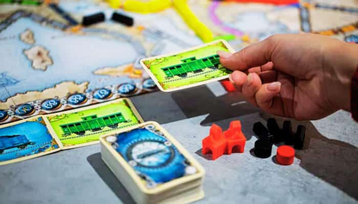 Ticket to Ride - Live Casino Magic - Live CasinoMagic Best board games: A close-up of cards and game pieces from Ticket to Ride, showcasing the gameplay of one of the best board games for strategy and fun