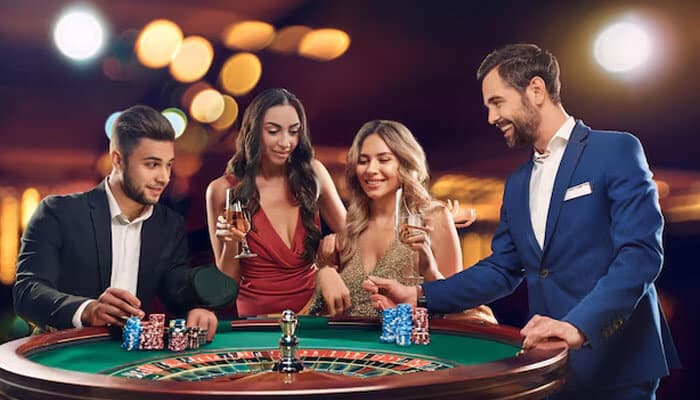 Why Choose Live Casino Games 1 - Live CasinoMagic Players enjoying live casino games at a roulette table with professional dealers in a luxury casino atmosphere