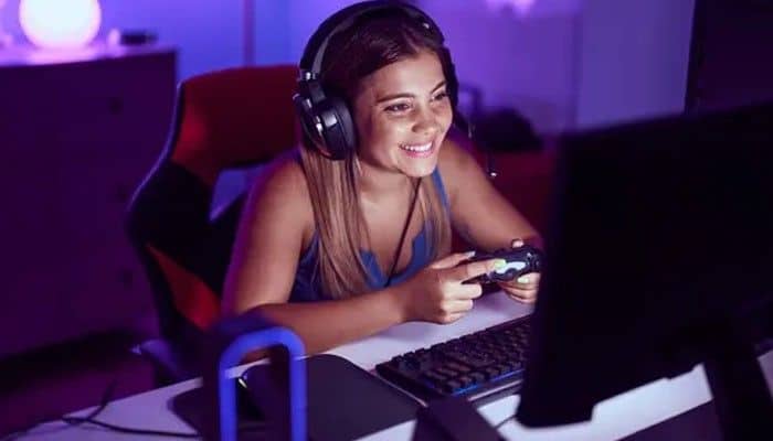 Improve internet stabilit - Live casino Magic - Live CasinoMagic Games Techoelite gaming setup featuring a smiling gamer wearing headphones and using a controller at a desktop computer with purple LED lighting.