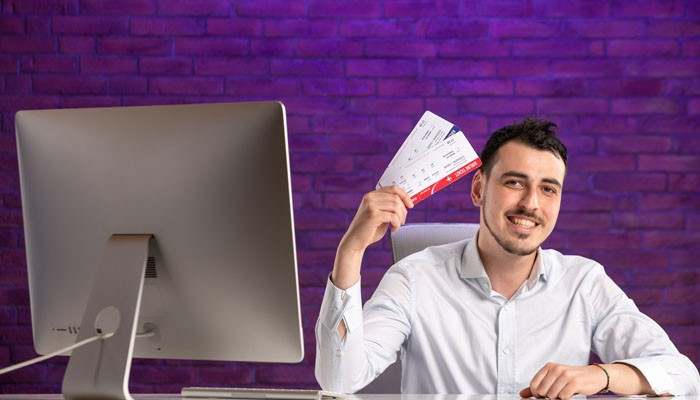 Match the Experience to Local Buyers - Live Casino Magic - Live CasinoMagic Site Gamificationsummit Method Ticket Sales showing a smiling event organizer holding tickets beside a computer to promote event bookings.